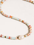 Necklace with multicolored beads and a pearl on a white background